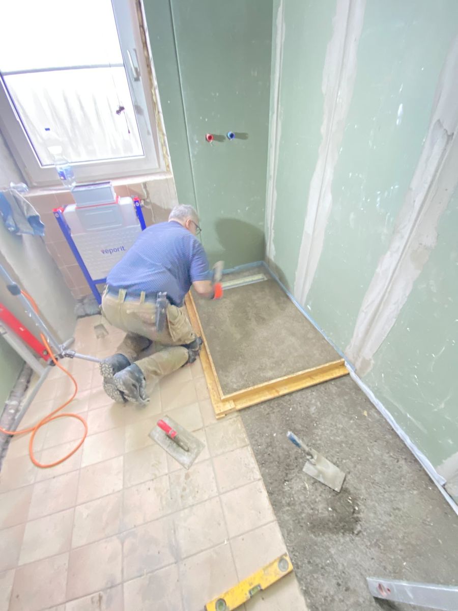 Mitarbeiter bei der Arbeit am Bodenaufbau im Bad
